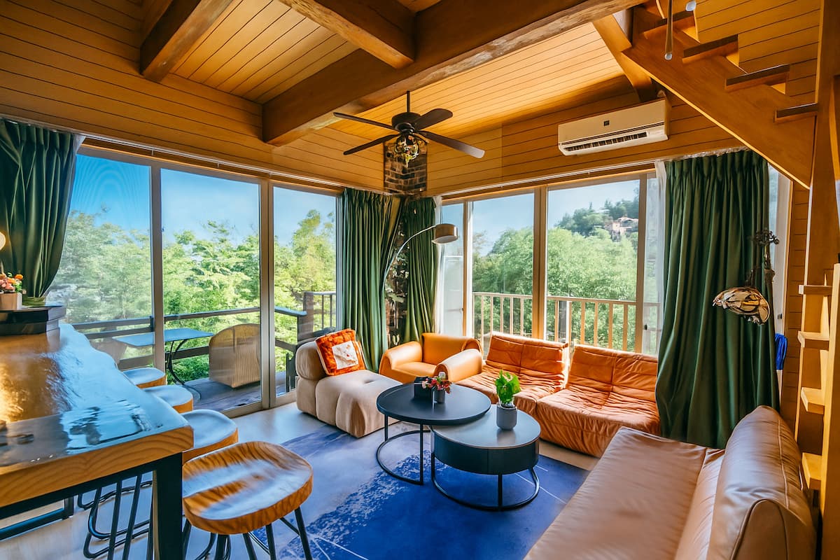 Villa onsen à Atami — salon chalet en bois, baies vitrées sur la verdure