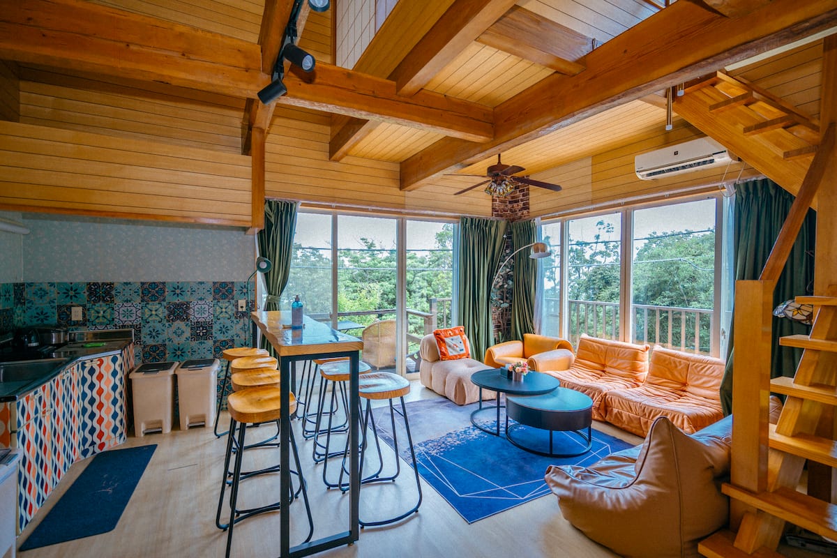 Séjour-cuisine ouvert sous mezzanine, bar et tabourets (photo Airbnb)